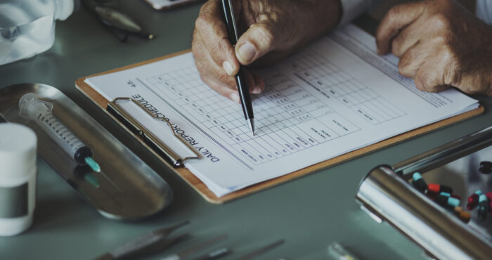 Closeup of doctor checking patient daily report checklist