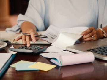 Hands of female entrepreneur working with bills and documents